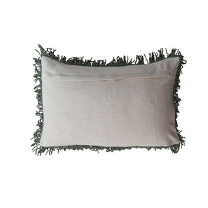 A rectangular light beige cotton lumbar pillow with dark green fringe trim along all edges, shown against a plain white background.