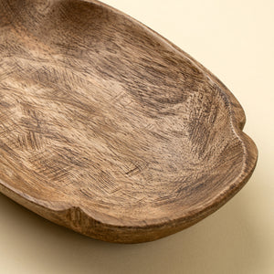 close up detail of a carved mango wood trinket tray. 