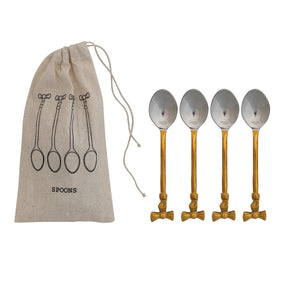 Set of four gold and silver spoons with bow handles next to a beige linen drawstring bag labeled 'SPOONS' on a white background.