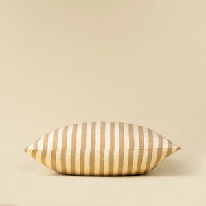 Striped linen pillow on a beige background from side profile view. 