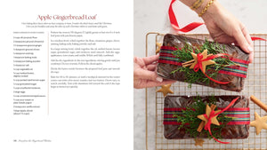 A recipe card page titled 'Apple Gingerbread Loaf' with ingredient text on the left and a photo on the right showing hands placing a decorated gingerbread loaf into a wire cooling rack. The photo includes a red ribbon, a gold ornament, and a star-shaped cookie.