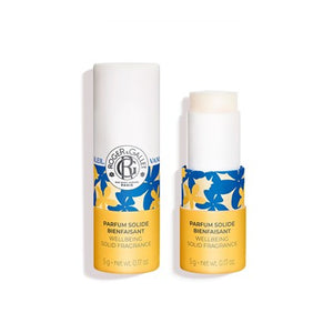 A Roger & Gallet Wellbeing solid fragrance stick in Vanille Soleil featuring a white cylindrical box and a matching solid perfume stick with a white cap and a yellow-and-blue floral label, shown on a white background.