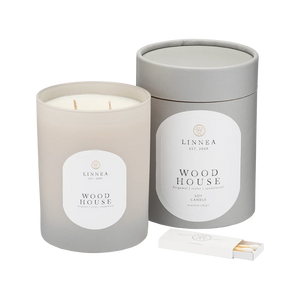 Scented candle in 'Wood House' fragrance with matching packaging on a white background. Linnea