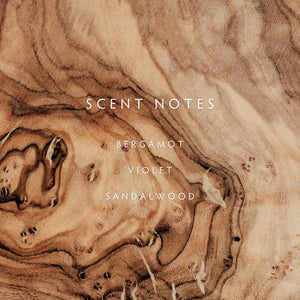 Text 'SCENT NOTES BERGAMOT VIOLET SANDALWOOD' on a brown and beige swirled background