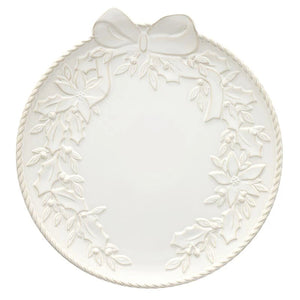 An off-white ceramic Christmas plate featuring embossed holly and mistletoe designs around the border, with a large bow motif at the top and a twisted rope-style rim.