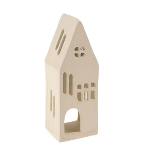 A small beige metal house-shaped candle holder with cutout windows and an arched doorway, shown on a plain white background.