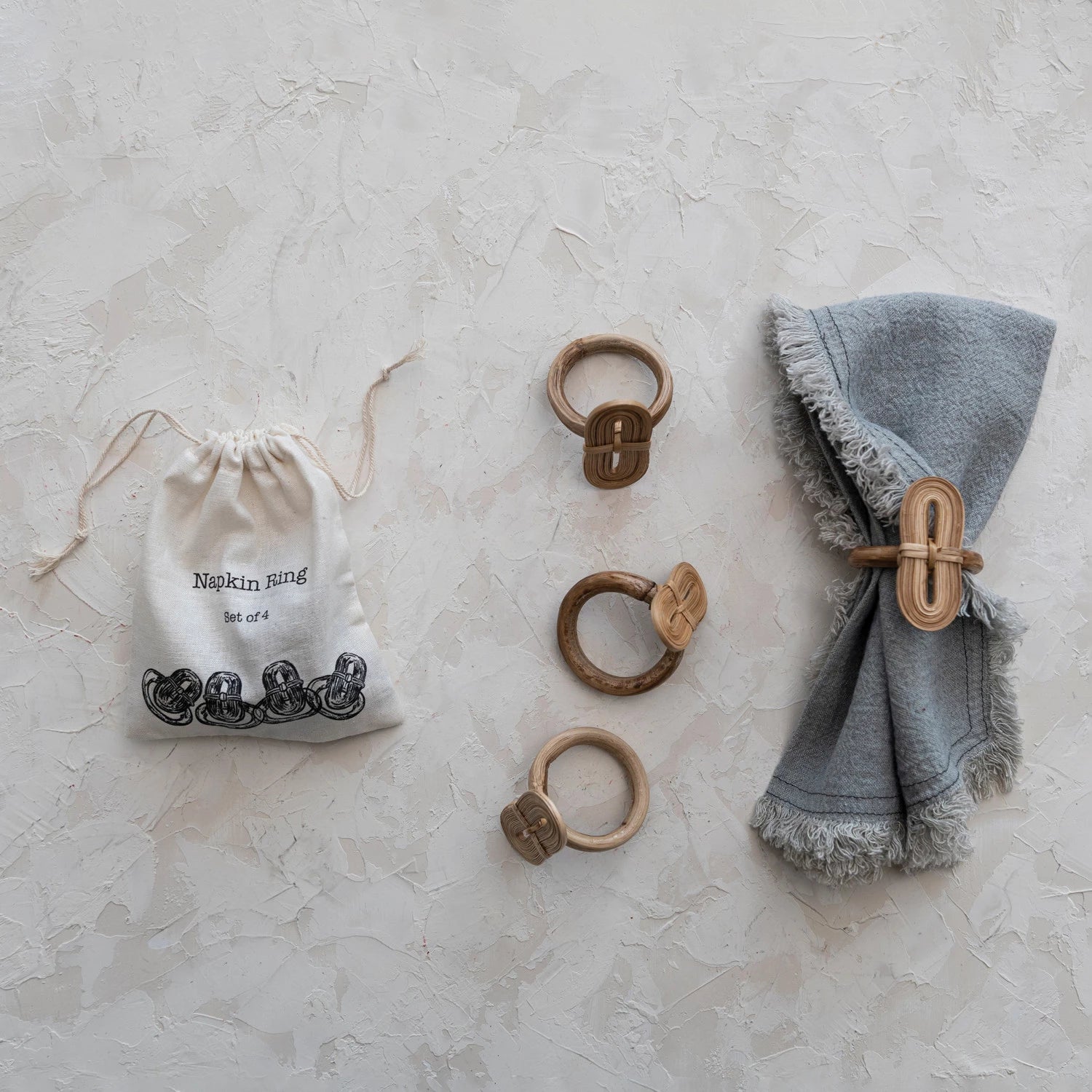set of four natural handmade bamboo napkin rings displayed on linen cloth. 