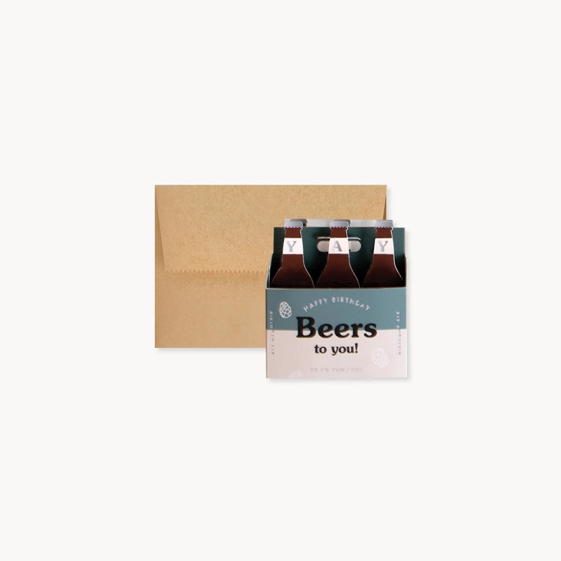 Pop up paper six-pack of beer with a 'Happy Birthday Beers to You' card and envelope on a white background