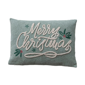 A rectangular decorative throw pillow in a muted sage green color, featuring 'Merry Christmas' embroidered in white script with green holly leaves and small red berries.