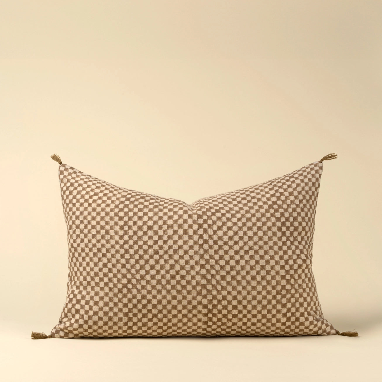 Decorative linen lumbar pillow with a check block pattern on a beige background. 