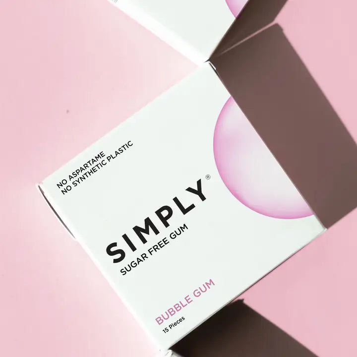 A box of Simply Sugar Free Bubble Gum on a pink background, with the brand name 'SIMPLY' in bold black text and a pink bubble graphic on a white box.