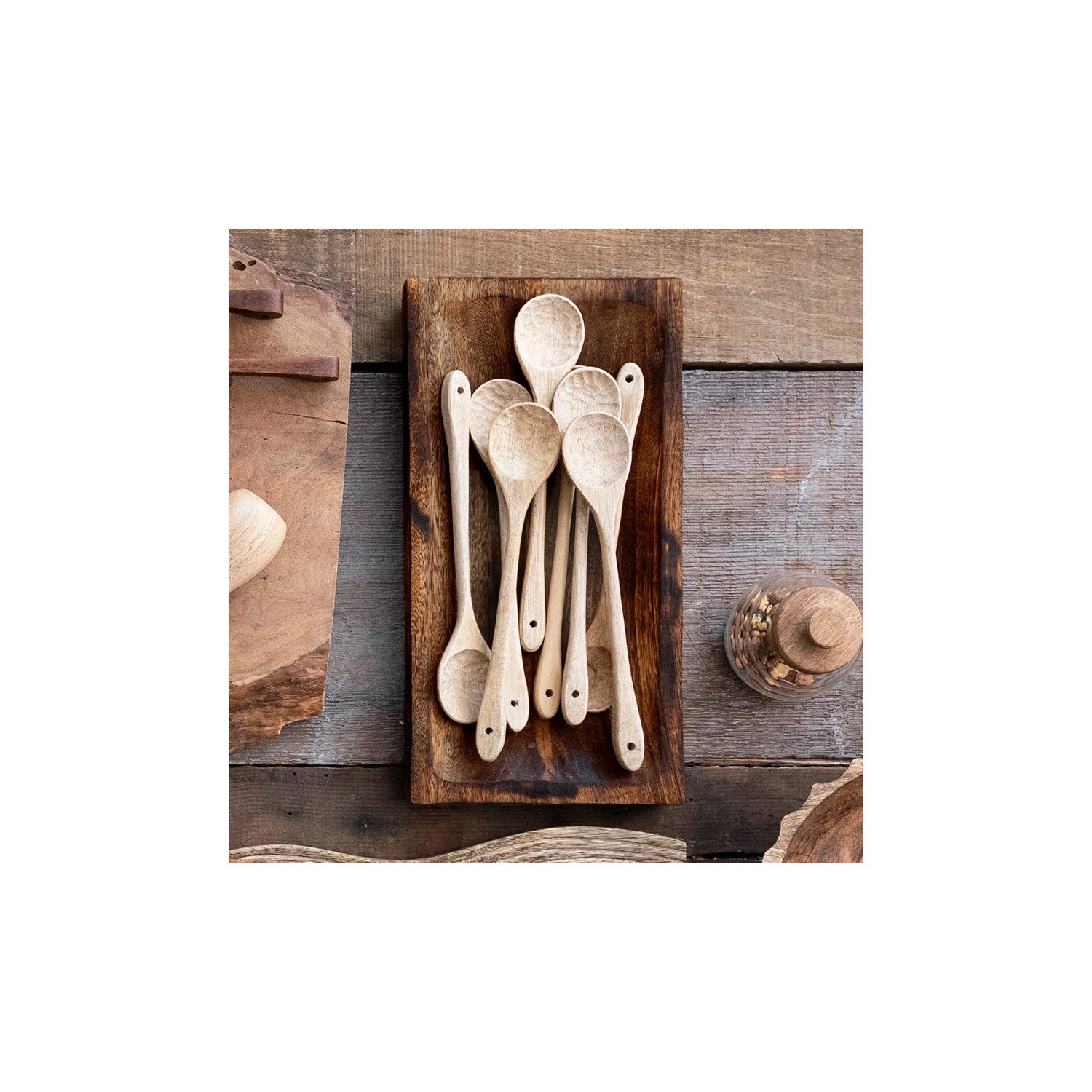 Burnt finish mango wood tray in rectangular shape with wooden spoons displayed. 
