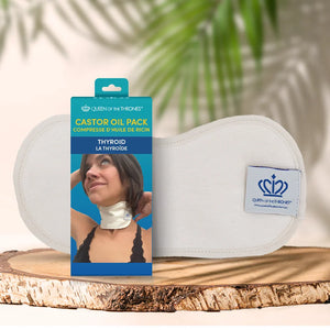 Castor oil pack for thyroid with packaging labeled 'Queen of the Thrones' on a wooden surface.