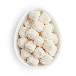 White spherical candies in a bowl on a white background