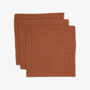 three clay textured washcloths on a white background