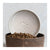 Individual ceramic debossed paw print dog bowl placed inside another dark brown ceramic dog bowl filled with dry kibble. 