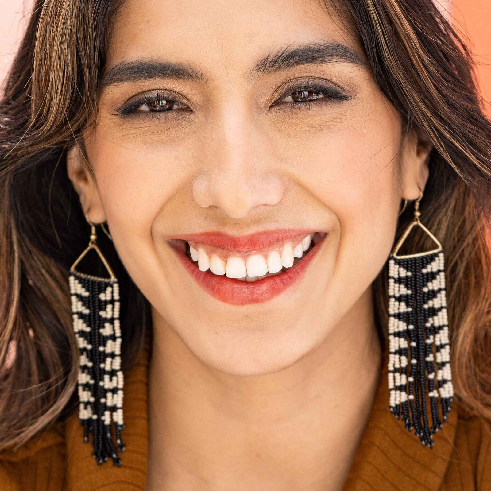 model wearing black and white arrow beaded fringe earrings. 