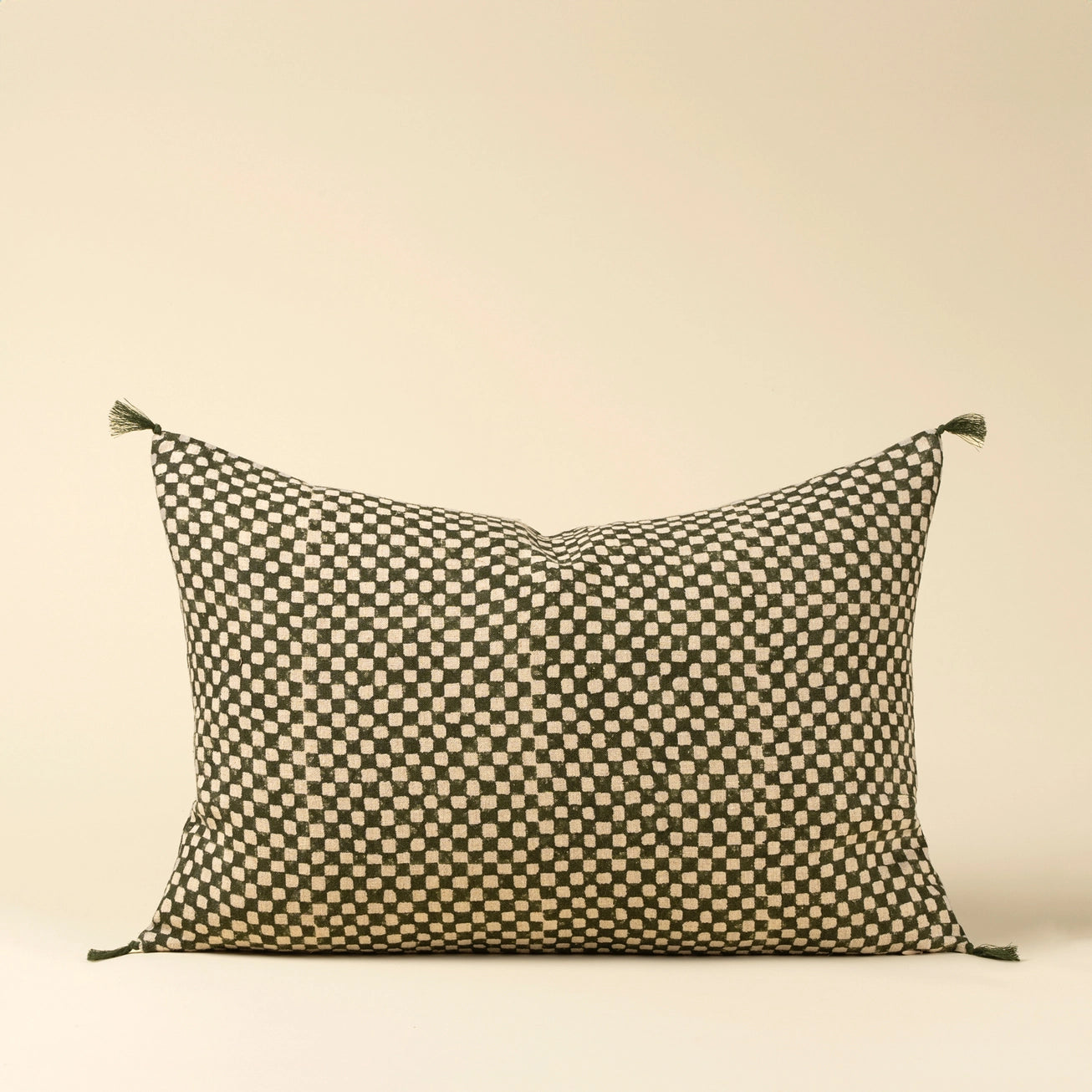 Decorative lumbar pillow with a checkered green pattern on a beige background