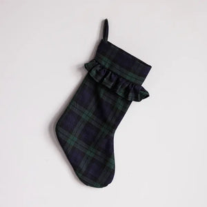 A dark tartan plaid Christmas stocking with a ruffled cuff and a hanging loop, shown against a plain light gray background.