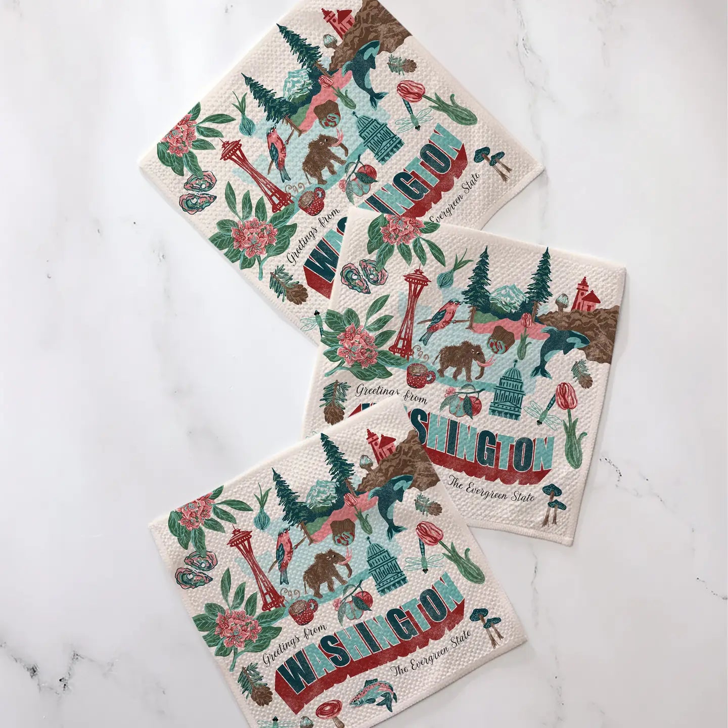 Set of three decorative dishcloths with Washington themed designs on a marble surface