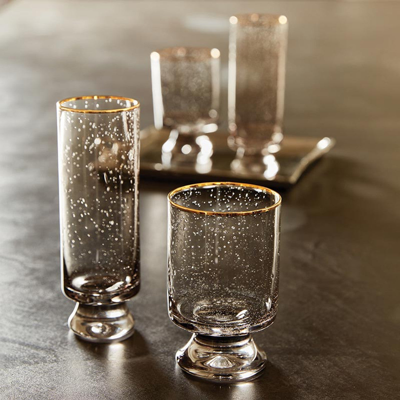 Gold rimmed grey seeded champagne and old fashioned glasses