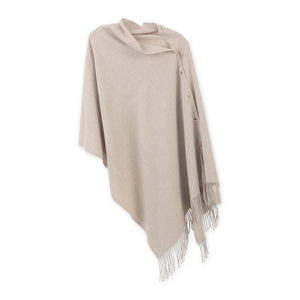 Oatmeal poncho with gold snaps and fringe.