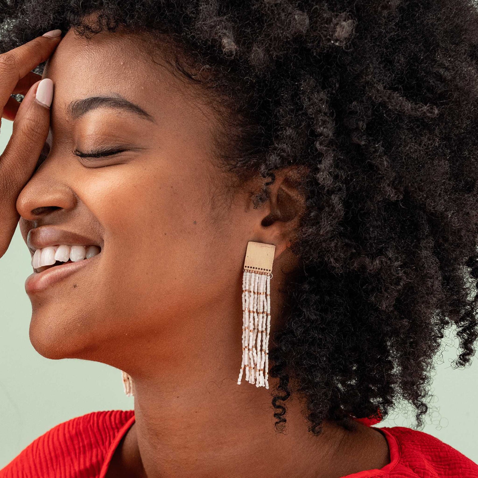 Model wearing Solid brass and ivory beaded fringe earrings. 