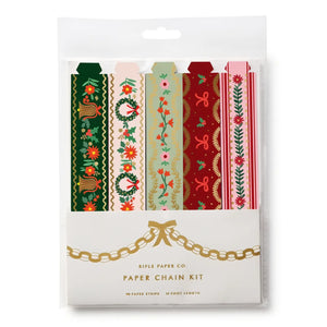 Rifle Paper Co. Paper Chain Kit containing six festive patterned paper strips in green, pink, red, and beige, packaged in a clear plastic sleeve with a white cardboard insert featuring gold chain graphics.