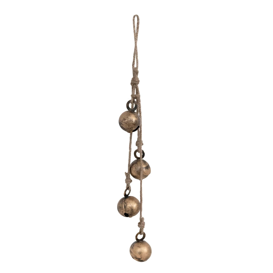 A set of gold metal jingle bells attached to a jute rope for hanging as a decoration.