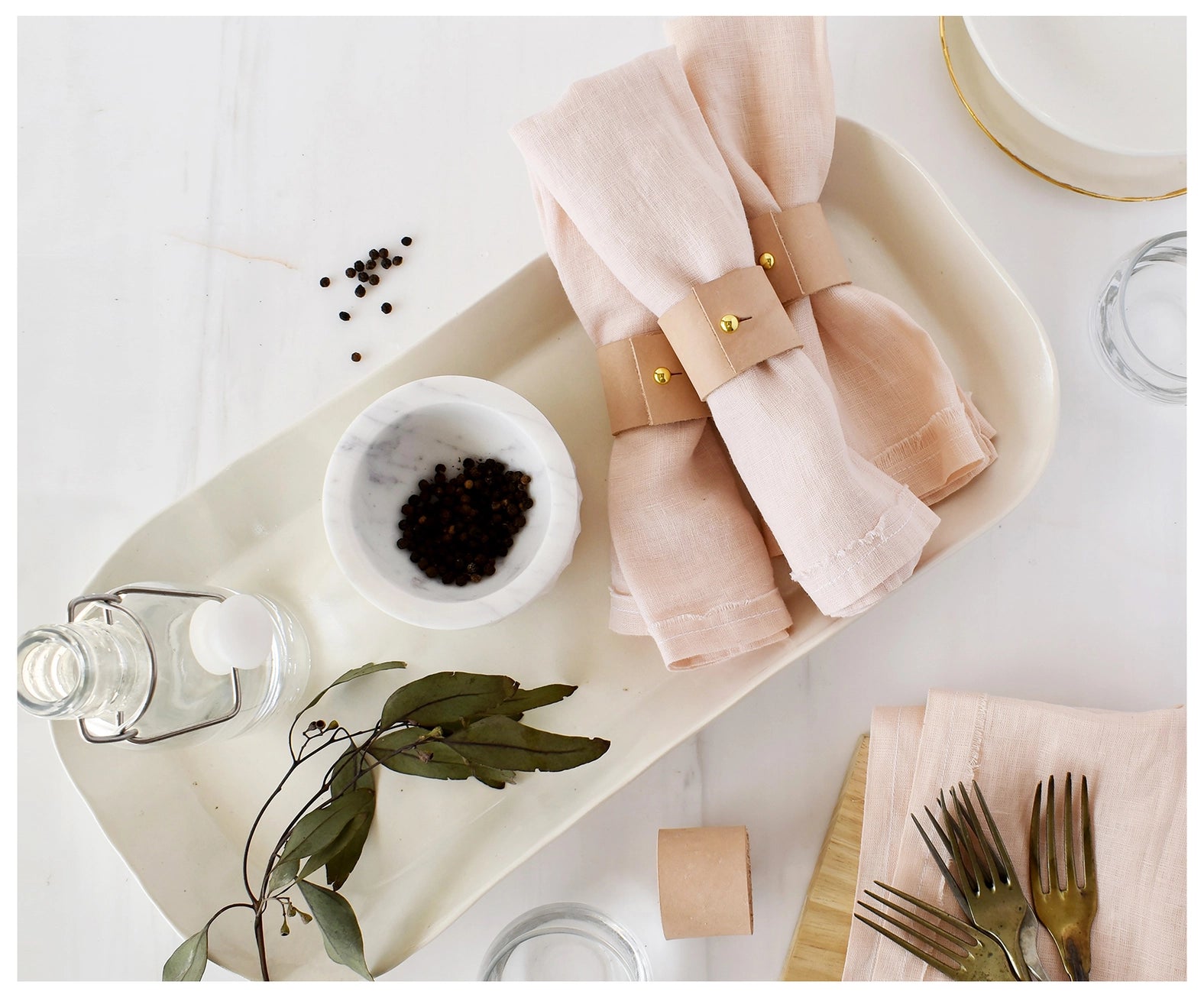 Genuine leather napkin rings displayed on linens. 