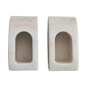 Two rectangular marble bookends with a central oval opening on a white background