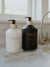 Clear Lucite tray in medium size displaying a matte collection of high performing hand lotion and hand soap. LAVANT