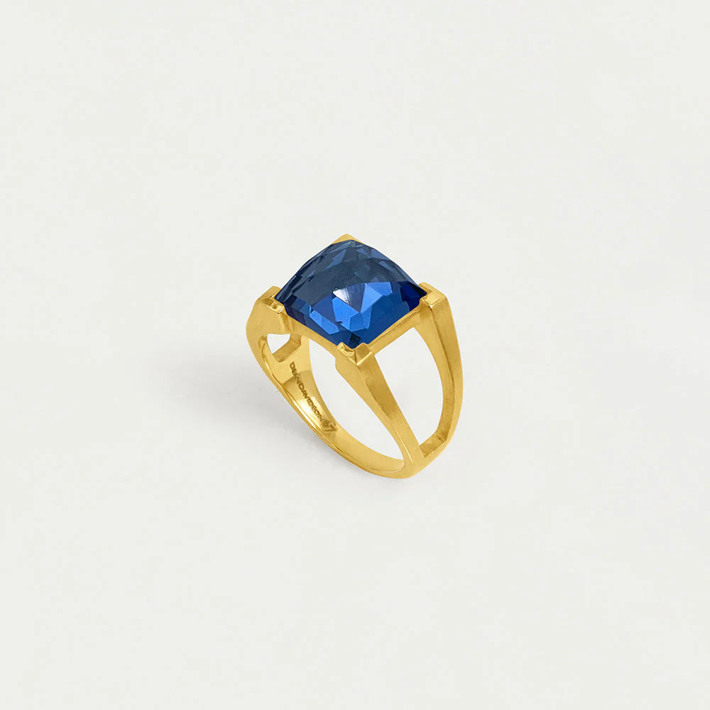 Gold ring with a midnight blue gemstone on a light gray background. Dean Davidson jewelry
