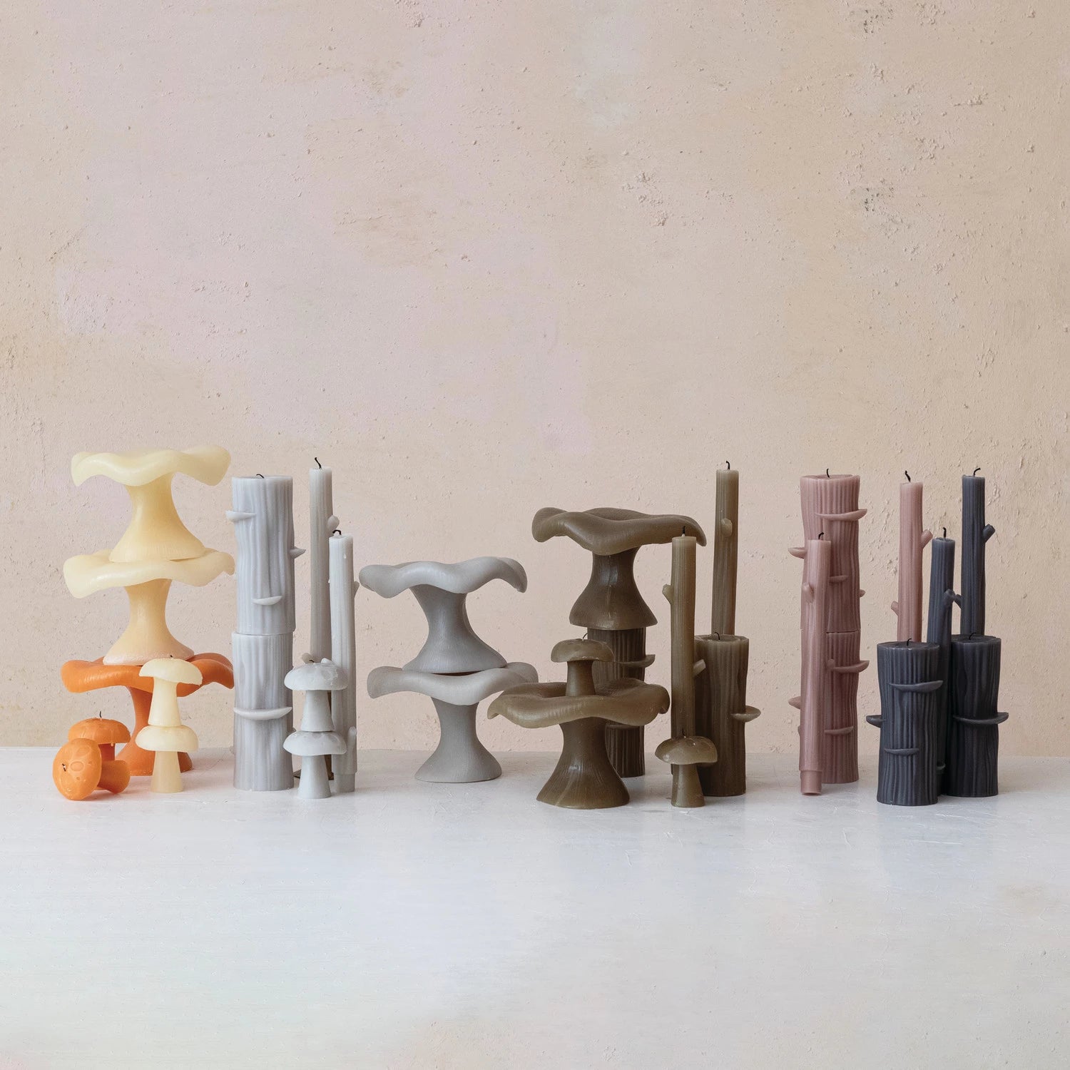 Colorful mushroom and tree stump shaped candle displayed on a marble counter.