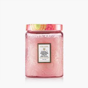 Pink candle jar with decorative lid and Voluspa label on a white background