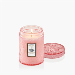 Pink candle with a textured lid on a white background