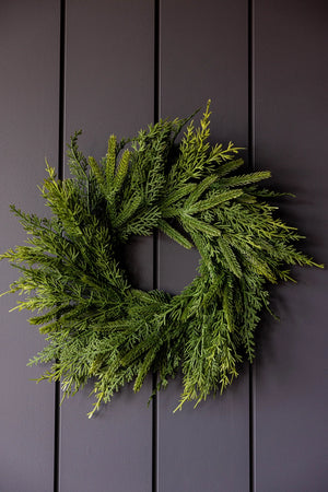 Green wreath on a dark wooden panel background