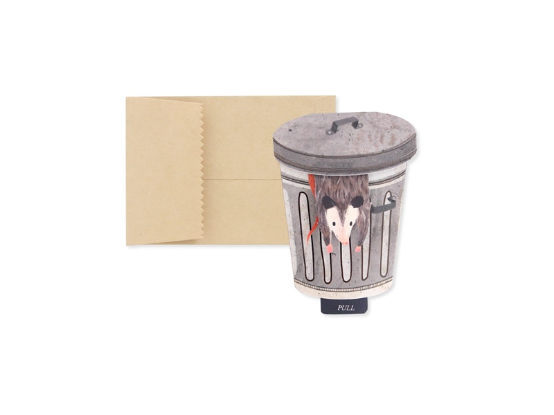Pop up greeting card of a possum in a trash can on a white background with brown envelope included. 