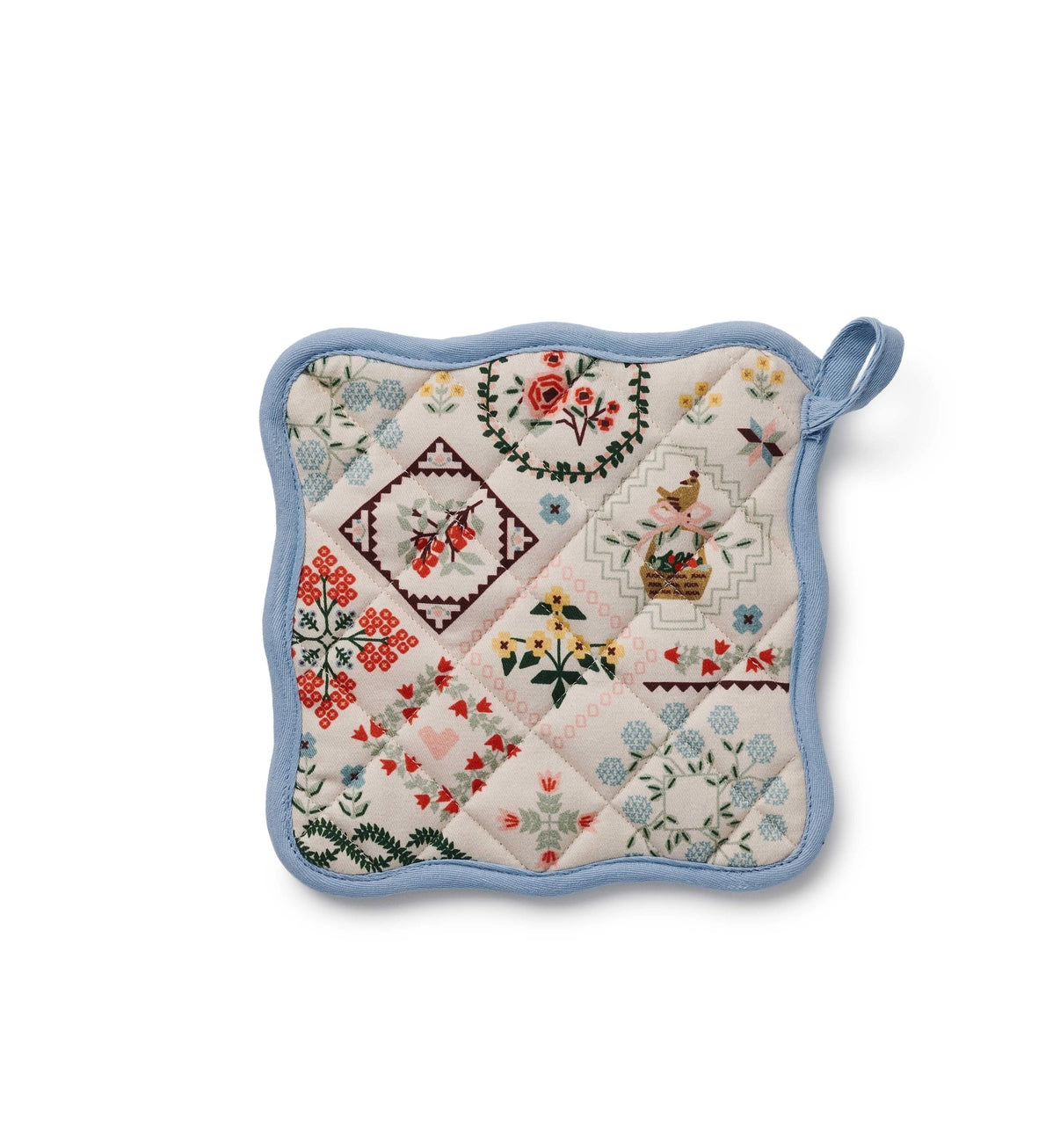 Quilted pot holder with floral and geometric farm animal patterns on a white background. 