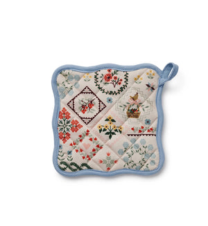Quilted pot holder with floral and geometric farm animal patterns on a white background. 
