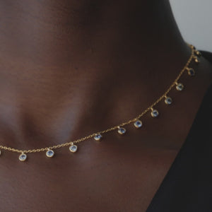 video of model wearing gold chain necklace with cubic zirconia pendant stones. Dean Davidson fine jewelry. 