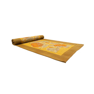 Rolled mustard yellow, orange, and gold autumn themed table runner on a white background. Couleur Nature. 