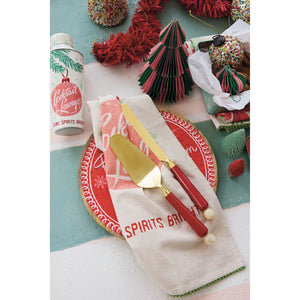 holiday table setting with retro red, gold, and green themed decor featuring red and gold dessert servers. 