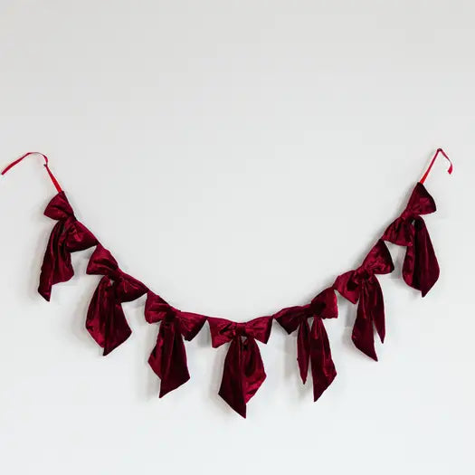 Red velvet bow banner garland on a white background. 