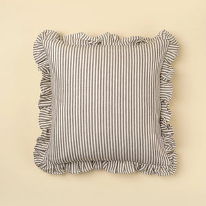 Striped grey linen/cotton pillow with ruffled edges on a beige background