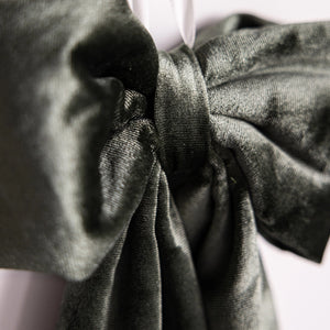 Close-up of a green fabric with a bow detail on a white background