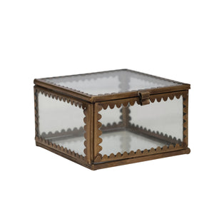 Scalloped edge brass trinket box with glass sides on a white background.