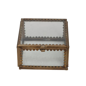 Decorative glass box with a brass scalloped edge closed on a white background. 