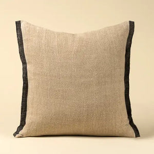 Beige belgian linen pillow with charcoal selvage trim on a beige background. 