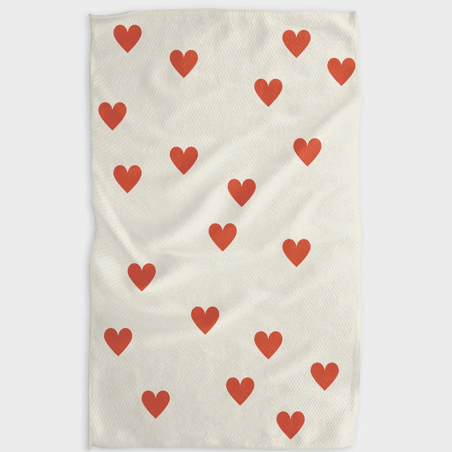 Beige towel with red heart pattern on a white background